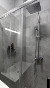 una doccia con porta in vetro in bagno di URBAN VILLA APARTMENT a Opatija