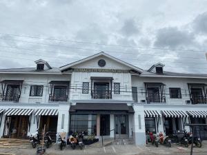 杜马格特Dumaguete Seafront Hotel的一座白色的建筑,前面停有摩托车