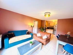 salon z niebieską kanapą i stołem w obiekcie *Le Golden Blue* Magnifique T3 à 5min du centre avec parking gratuit w mieście Bellegarde-sur-Valserine
