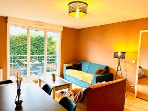 salon z kanapą i stołem w obiekcie *Le Golden Blue* Magnifique T3 à 5min du centre avec parking gratuit w mieście Bellegarde-sur-Valserine
