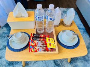 una mesa de madera con 2 botellas de agua y aperitivos en PaPa Q suite Resort en Roi Et