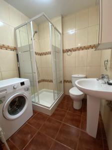 a bathroom with a washing machine and a sink at CASA CORALES in La Mareta