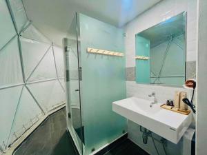 a bathroom with a sink and a glass shower at PaPa Q suite Resort in Roi Et