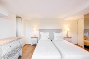 a white bedroom with a large bed and two lamps at Villa d exception avec terrasse, jacuzzi, vue mer, parking, en plein cœur du village de Eze in Éze