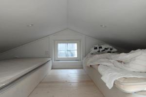 a white room with a bed and a window at Attefallshus Nära Havet Norranäs in Varberg