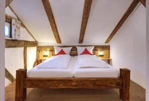 ein Schlafzimmer mit einem Holzbett mit zwei roten Kissen in der Unterkunft Jurahaus Pröll Ottmaring in Dietfurt