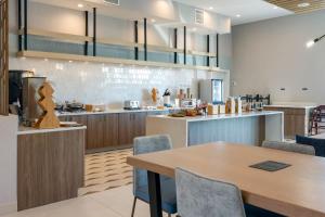 a kitchen with a wooden table and chairs at Fairfield by Marriott Inn & Suites Canton Riverstone Parkway in Canton