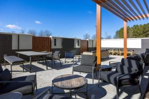 eine Terrasse mit Tischen, Stühlen und einem Tisch in der Unterkunft Fairfield by Marriott Inn & Suites Canton Riverstone Parkway in Canton