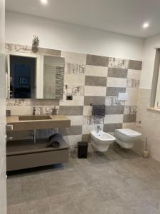 uma casa de banho com um lavatório, um WC e um espelho. em La Casa nel Bosco em Siena
