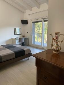 Un dormitorio con una cama y un escritorio y una ventana. en La Casa nel Bosco, en Siena