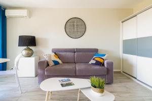 sala de estar con sofá y mesa en SELECT'SO HOME - Studio au cœur du Lavandou-Services hôteliers-AREV, en Le Lavandou