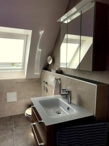 W łazience znajduje się umywalka i lustro. w obiekcie Ferienhaus Sunset w mieście Gräfensteinberg