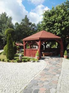 einen hölzernen Pavillon mit einer Bank in einem Park in der Unterkunft Dom całoroczny Wczasy jak Marzenie in Ruciane-Nida