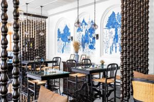 un restaurante con mesas y sillas negras y paredes azules en Away Chiang Mai Thapae Resort A Vegan Retreat - SHA Extra Plus, en Chiang Mai