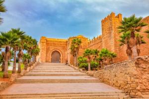 a brick building with palm trees and a staircase at Luxueux Appartement DOWNTOWN RABAT in Rabat