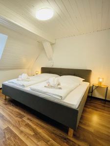 a bedroom with a large bed with white sheets at Apartment Rheingold in Schwabach