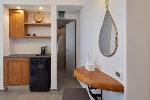 a kitchen with a black refrigerator and a mirror at Allure Breeze Suites in Oia