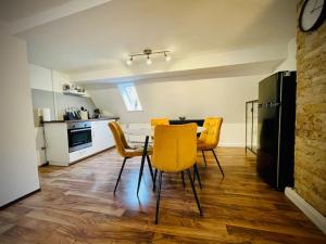 a kitchen and dining room with a table and yellow chairs at Apartment Rheingold in Schwabach