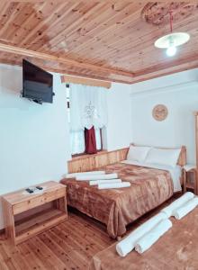 a bedroom with a large bed and a flat screen tv at Hotel Domino in Gjirokastër