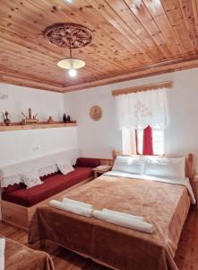 a bedroom with two beds and a wooden ceiling at Hotel Domino in Gjirokastër