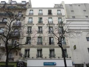 um edifício branco alto com muitas janelas em Hôtel des Buttes Chaumont em Paris