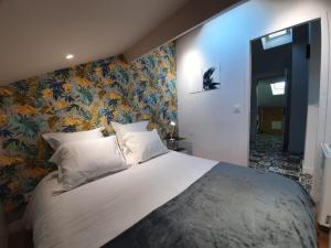 ein Schlafzimmer mit einem großen weißen Bett mit Blumentapete in der Unterkunft Stop Chez M Select Saga # Qualité # Confort # Simplicité in Saint-Fons