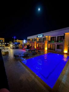 a large swimming pool at night with a hotel at Agartha Suite Hotel Kemer in Kemer