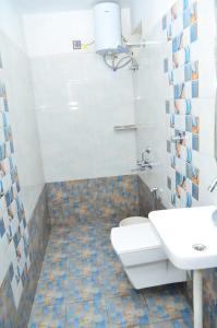 La salle de bains est pourvue de toilettes et d'un lavabo. dans l'établissement HILLINGTON COTTAGE, à Kodaikānāl