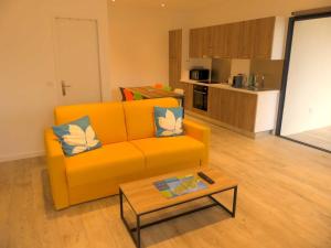 a living room with an orange couch and a coffee table at Les Terrasses d'Erbalunga in Erbalunga