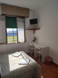 a bedroom with a bed and a table and a window at Hotel Italia in Reggio Emilia