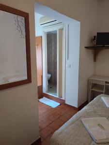 a room with a mirror and a bed and a bathroom at Hotel Italia in Reggio Emilia