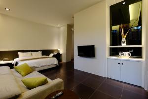una camera d'albergo con letto e divano di Tongzhan Design Inns ad Anping