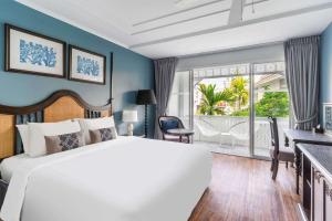 1 dormitorio con 1 cama blanca grande y balcón en Away Chiang Mai Thapae Resort A Vegan Retreat - SHA Extra Plus, en Chiang Mai