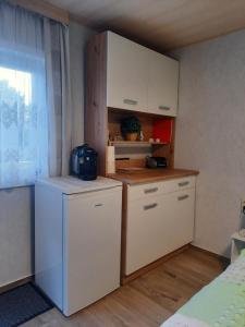 una piccola cucina con armadietti bianchi e frigorifero di Pfaffensteinblick Reymann a Königstein