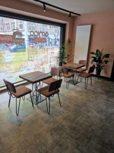 a room with tables and chairs and a large window at Amigo Hotel in Amsterdam