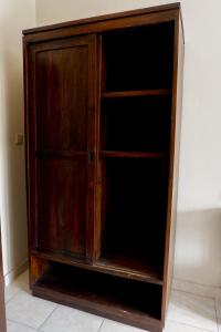 a wooden cabinet sitting against a wall at Puri Panca Jaya Hotel in Seminyak