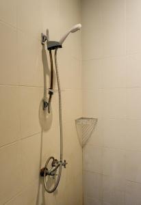 a shower with a shower head in a bathroom at Puri Panca Jaya Hotel in Seminyak