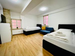 a room with two beds and a blue couch at Apartment Goldschmied in Schwabach