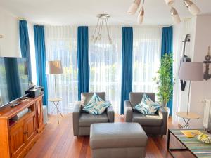 a living room with two chairs and a tv at Residenz Bismarck - Ferienwohnung Maris in Ahlbeck