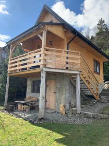 eine große Holzhütte mit Balkon oben in der Unterkunft Domek pod smrekami in Ropa