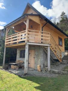 a large wooden cabin with a balcony on top at Domek pod smrekami in Ropa