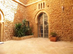 een stenen gebouw met een grote deur en planten bij Riad Marco Andaluz in Sale