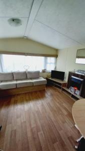 a large living room with a couch and a table at Sea View Caravan Golden Sands Holiday Park in Conwy