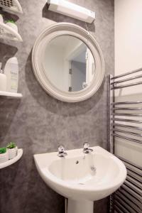 uma casa de banho com um lavatório e um espelho em Apartments in the heart of Penzance em Penzance
