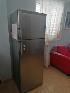 a refrigerator in a room with a red couch at Amber House in Arinaga