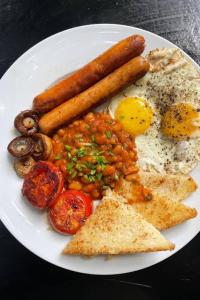 a plate of food with sausage and beans and eggs at 74 on retief Guesthouse in Potchefstroom
