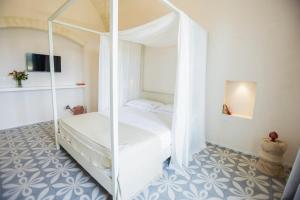 a bedroom with a white bed with a canopy at Dimora La Scaledda in Serranova