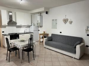 a kitchen and a living room with a couch and a table at Patrizia Apartement in Chioggia