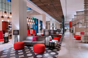 a lobby with couches and red chairs in a store at Marriott Port-au-Prince Hotel in Port-au-Prince