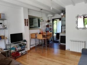 een woonkamer met een tafel en een keuken bij Precioso apartamento con jardín in Prellezo